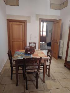 ein Esstisch mit Stühlen und einer Schüssel darauf in der Unterkunft Corte San Gabriele in Galatina