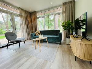 una sala de estar con un sofá y una mesa en Ferny Cabin, en Haarle