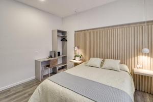 a bedroom with a bed and a wooden wall at Colina Inn in Escazu