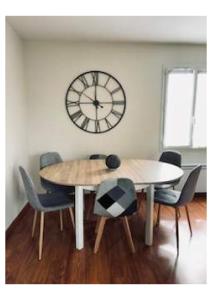 a dining room with a table and a clock on the wall at La Giraudière in Cellettes