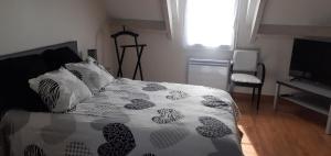 a bedroom with a bed with a black and white comforter at La Giraudière in Cellettes