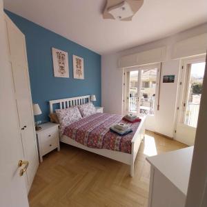 a bedroom with a bed and a blue wall at Casa Marie in Marina di Modica