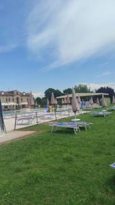 a group of picnic tables with umbrellas on the grass at Locanda Corte Arcangeli in Ferrara