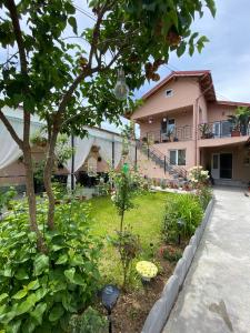 a garden in front of a pink house at Casa Tomița in 2 Mai