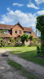 una gran casa de ladrillo con una valla de madera en Ferienwohnungen Bauernhof Beckmann en Winsen