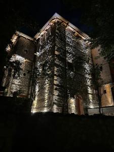 un gran edificio con luces encendidas por la noche en Kulla Hupi Agriturism, en Bulqizë