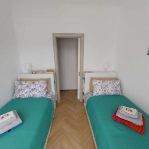 two beds in a room with green sheets at Casa Marie in Marina di Modica