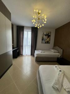 um quarto de hotel com duas camas e um lustre em Cozy Apartments em Tirana
