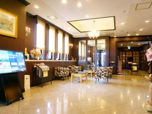 a lobby with a waiting room with tables and chairs at APA Hotel Honhachinohe in Hachinohe