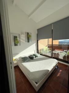 a bedroom with a bed and a large window at Appartement vue sur mer, piscine, garage privé in Bormes-les-Mimosas