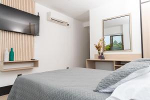 1 dormitorio con cama y espejo en DUSANO BOUTIQUE HOTEL en Santa Marta