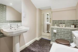 a bathroom with a sink and a toilet at The Old Kitchen Exford in Wheddon Cross +25 photos