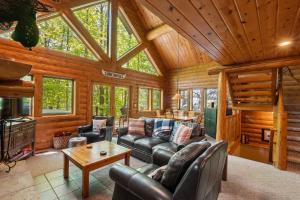 a living room with leather furniture in a log cabin at 803 Mountain Cabin in Boyne Falls