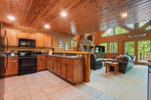 a kitchen with wooden cabinets and a living room at 803 Mountain Cabin in Boyne Falls