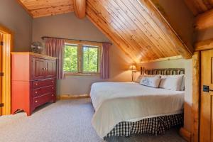 a bedroom with a bed and a wooden ceiling at 803 Mountain Cabin in Boyne Falls