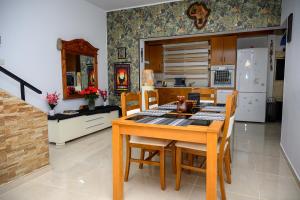 eine Küche mit einem Holztisch mit Stühlen und einem Kühlschrank in der Unterkunft Demetris apartment in Meneou
