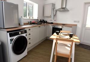 a kitchen with a dishwasher and a table and a microwave at Pet-friendly boutique beach retreat in Uphill +7 photos
