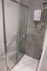 a shower with a glass door in a bathroom at Pet-friendly boutique beach retreat in Uphill
