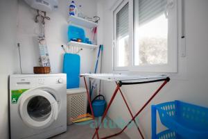 lavadero con lavadora y mesa en Apartamentos Zona Porteta, en Peñíscola