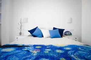 1 dormitorio con 1 cama con almohadas azules y blancas en Apartamentos Zona Porteta, en Peñíscola