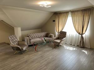 a waiting room with a couch and two chairs at Casa Cristina in Tuzla