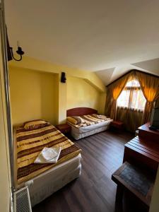 a room with two beds and a piano at Хотел-механа Добърско in Dobărsko