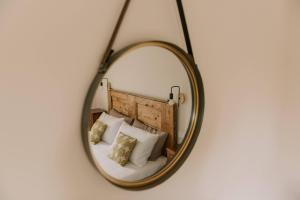 a mirror on a wall with a bed with pillows at Tenuta Malvolti - Al Vecchio Convento in San Fior di Sopra