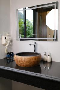 W łazience znajduje się drewniana umywalka z lustrem. w obiekcie Chay Moutain Valley Bugalow w mieście Ninh Binh