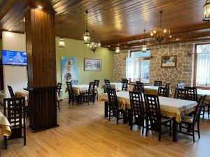 a restaurant with tables and chairs in a room at Hotel Bacelli Voskopoje in Voskopojë