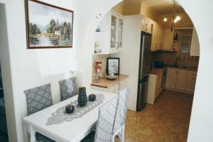 a kitchen and dining room with a white table and chairs at Vila Matias 8 in Gjirokastër