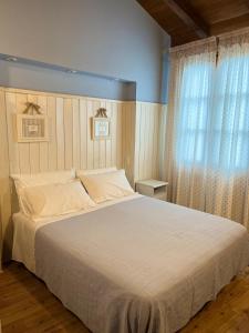 a bedroom with a large white bed and a window at Casa Fabiani - Vacanza in Toscana - via Francigena - Pet Friendly in Orentano +31 photos