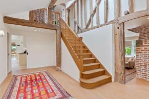a wooden staircase in a living room with a rug at The Manor at Minstrel Court with Hot Tub in Cambridge