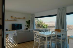 un salon avec un canapé, une table et des chaises dans l'établissement Villa Relajares, à Lajares