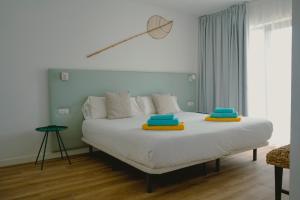 Un dormitorio con una cama blanca con almohadas azules y amarillas. en Villa Relajares, en Lajares