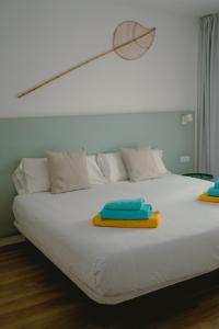 Una cama blanca con dos toallas encima. en Villa Relajares, en Lajares