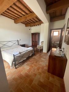 a bedroom with a bed and a wooden floor at Agriturismo Piandimaggio in Pienza