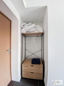 a room with a shelf with white towels on it at Marine Serenity - Appartement à 50m de la plage in Bray-Dunes
