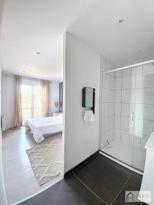 a white bathroom with a shower and a bed at Marine Serenity - Appartement à 50m de la plage in Bray-Dunes