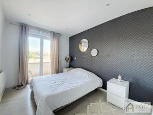 a bedroom with a white bed and a window at Marine Serenity - Appartement à 50m de la plage in Bray-Dunes