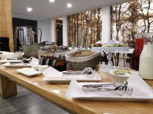 a table with plates and utensils on it at Hotel Costanera in Puerto Natales