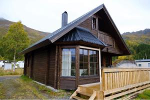a small wooden house with a large window on it at Kongsmark Hytteferie AS in Tengelfjorden