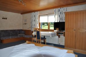 um quarto com uma cama, uma secretária e uma mesa em Haus Ritter 286 em Schoppernau