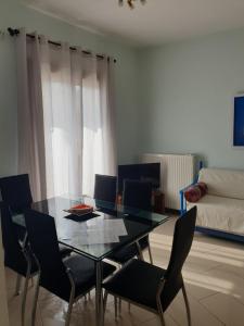 une salle à manger avec une table et des chaises en verre dans l'établissement Beautiful house in Aegina, à Égine