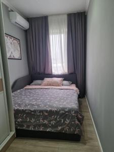 Bett in einem kleinen Zimmer mit Fenster in der Unterkunft Charming and modern apartment at heart of Tashkent in Taschkent