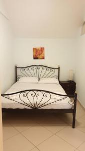 a bed with a black and white bed frame at Beautiful house in Aegina in Egina