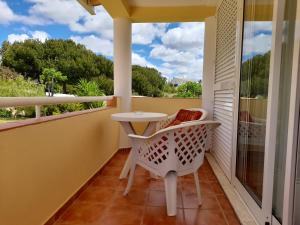 a balcony with a white table and chairs and a window at Aurora Sol in Luz