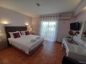 a bedroom with a bed and a tub and a television at Aurora Sol in Luz