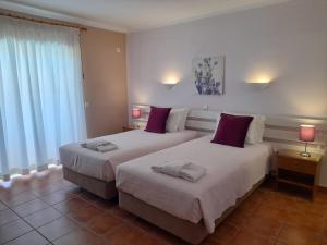 a bedroom with two beds and two lamps and a window at Aurora Sol in Luz