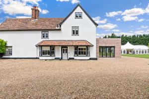 a large white house with a gravel driveway at The Manor at Minstrel Court with Hot Tub in Cambridge
