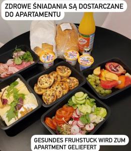 een tafel met vier dienbladen van verschillende soorten voedsel bij FARO Apartamenty Polanki Aqua Morskie Klimaty 4 baseny free parking in Kołobrzeg